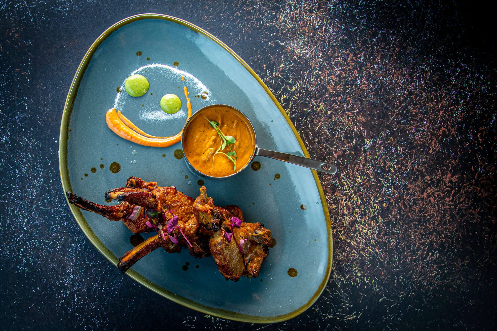Tandoor lamb chops on a teal plate